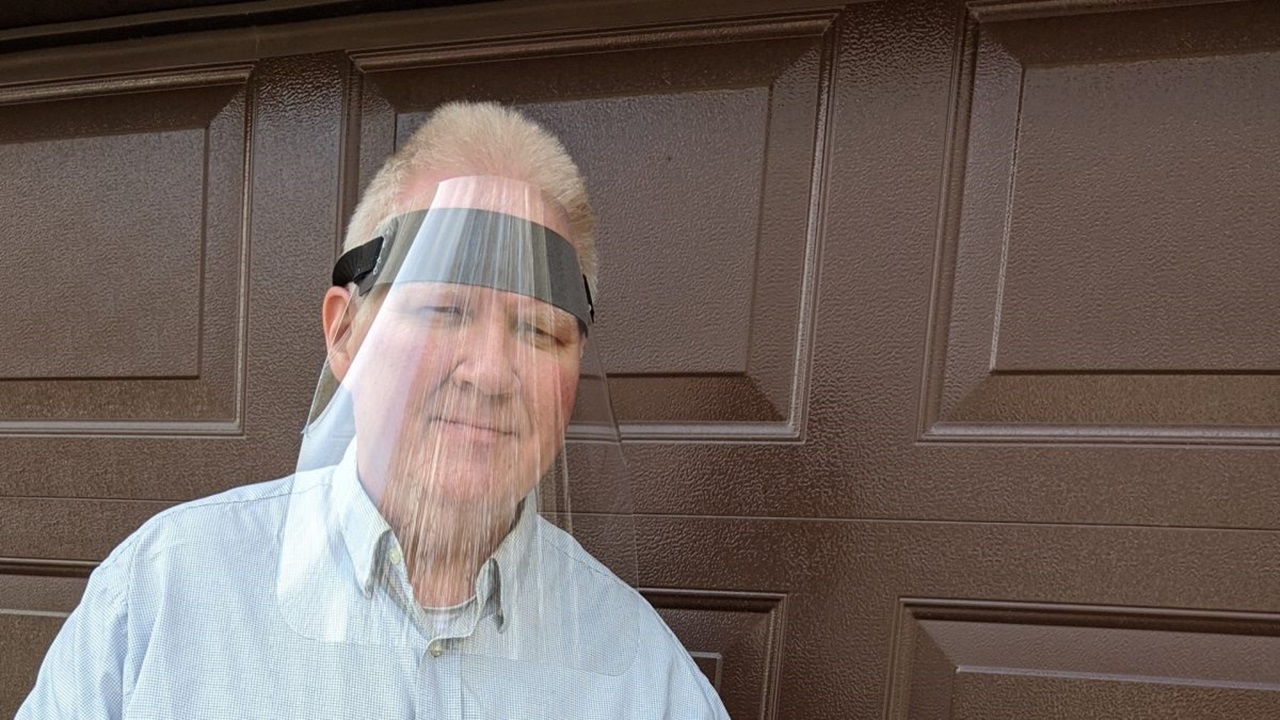 Barry Lawrensen wears a plastic face shield.