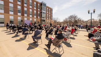 People sit in chairs at the ground breaking event at the USD School of Health Sciences.