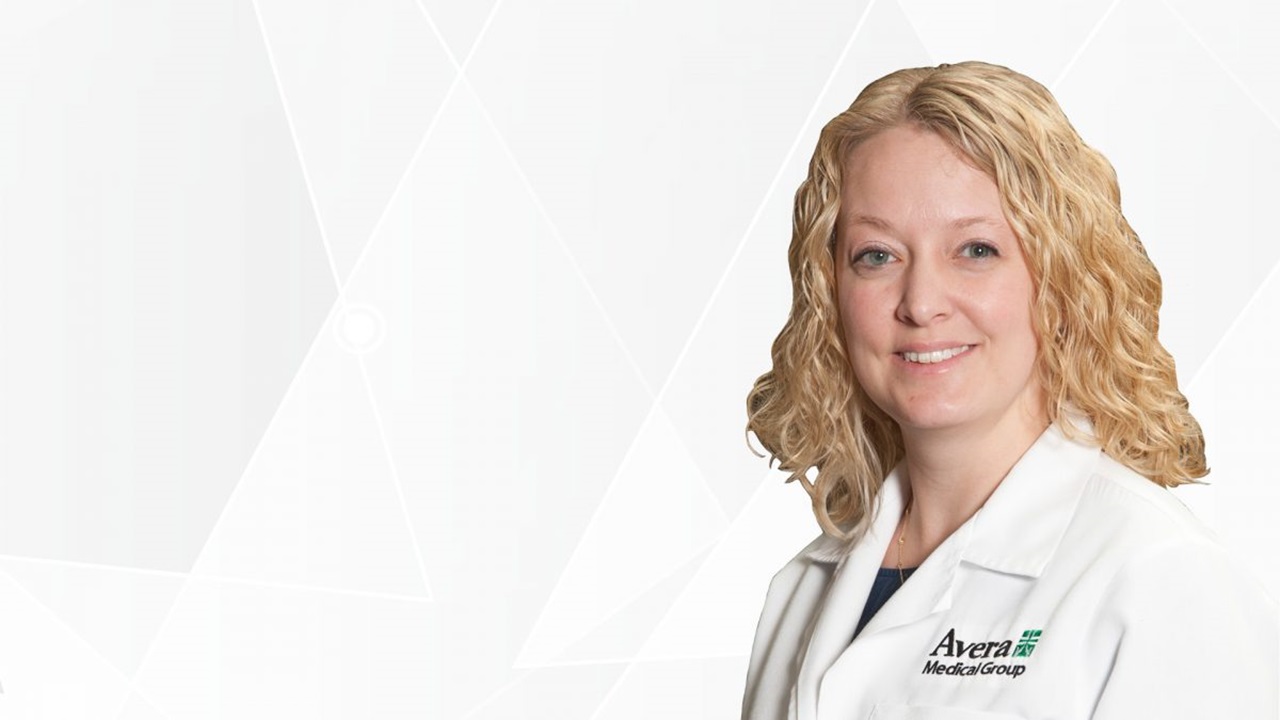 Leah Prestbo wears a white Avera lab coat and smiles in front of a white background.