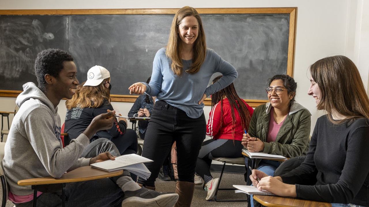 Louisa Roberts talks with a group of students in class. They are in a small group discussing. Louisa Roberts talks with a group of students in class. They are in a small group discussing.