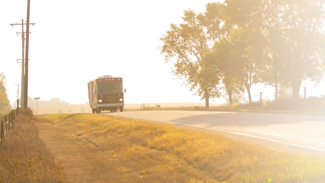 The Health Affairs Mobile Unit drives down the road at sunset.