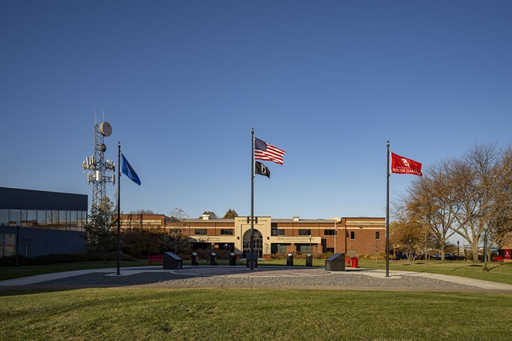 Photo of the Patriot's Plaza featuring the United States, South Dakota, and USD flags blowing in the wind