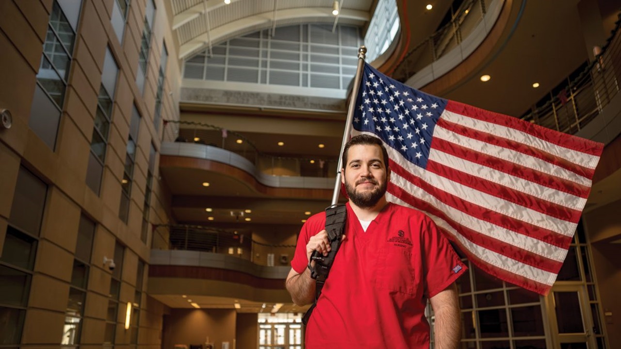 Krisztian Zsigmond Fasi holding an American flag on his back, smiling at the camera Krisztian Zsigmond Fasi holding an American flag on his back, smiling at the camera
