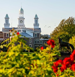 Old main in front of blossoming flowers.