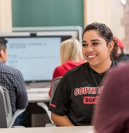 Students listening to a lecture and smiling.