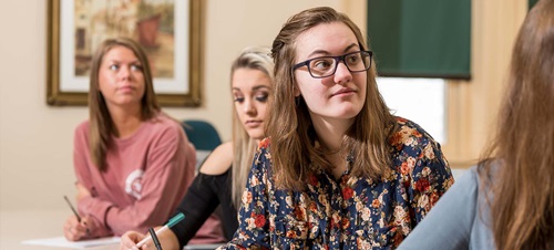 Students listening to a lecture and writing.