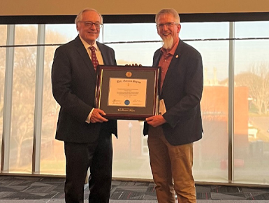 Instructor Henry Wiedrich receives chapter honoree gift from associate professor Rand Wergin.