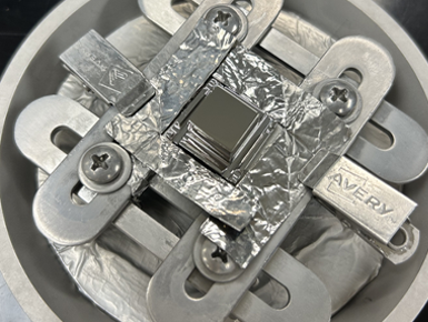 Close-up of a silver-colored HPGe detector with shiny, reflective parts, featuring a mix of smooth and textured surfaces.