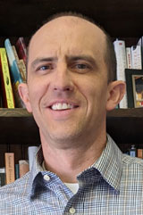 A portrait of Paul Formisano smiling.