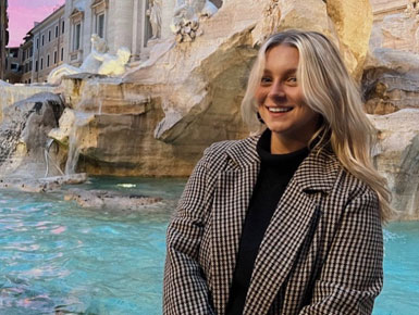 Emily Hensley sitting by fountain with waterfall in background outdoors