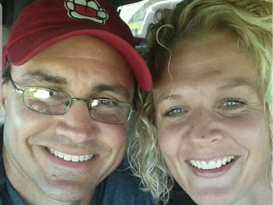 A selfie of Manny and Amy Scarmon geared up for a USD football game.