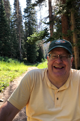 A photo of Cliff Summers sitting in a forest. 