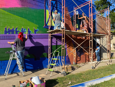 USD students and artists painting the mural in Centerville. 