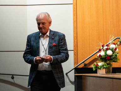 A photo of Scott Lawrence walking back to his seat after accepting his College of Fine Arts Hall of Fame award.