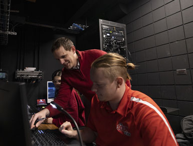 A USD professor and student work behind a sound board.