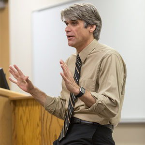 George Mader teaching in front of a classroom.