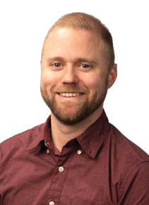 James Kroon posing for headshot in front of white wall