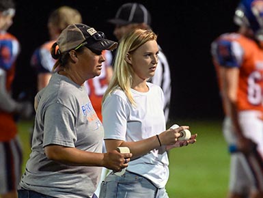 Maria Koenen on the football field standing next to the head coach.