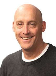 Brock Rops standing in front of white wall for headshot
