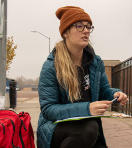 A member of the Midwest Street Medicine Program sits and talks with patients.