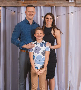 Molly Lien stands with her family against a backdrop of white curtains and string lights.