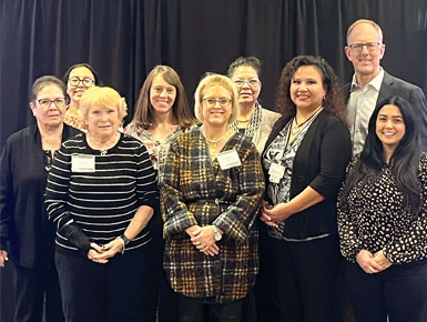 Dr. Daniel Petereit's Walking Forward team posing for photo in front of black tarp