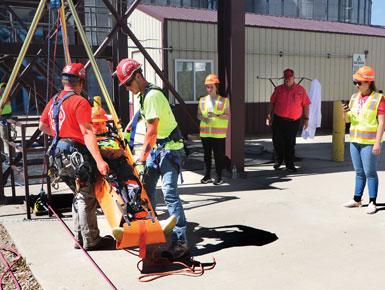 During training, a participant is loaded on a gurney while others take notes