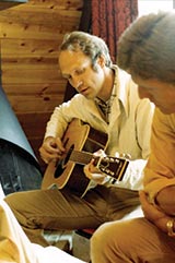 Photograph of Melvin W. Thomas playing a guitar at a family gathering in July 1891.