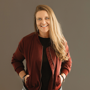 Meredith Allen, M.S. ’09, B.M. ’05, stands against a brown backdrop posing for a photo.