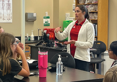 A health science teacher instructing young students in class during an event.