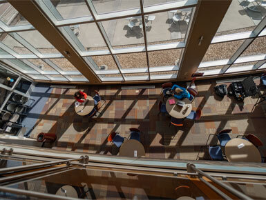 USD – Sioux Falls students sit in the commons area studying on their laptops.