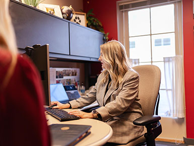 Ahslin Schoenfelder works at her computer with a student.
