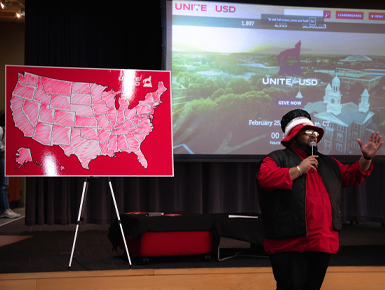 USD staff member speaks to the audience in front of the Unite for USD donor map.
