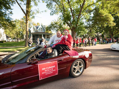 James Clement sits with a friend in a red sports car during the Dakota Days parade.