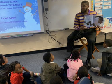 DeValon Whitcomb reading to a class of students.