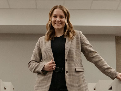 Brooklyn Bollweg standing in lecture hall walkway