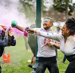 Students throwing colored powder during Holi festival celebration