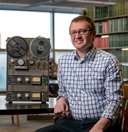 Male Sitting Next to Old Tape Recorder in the Library